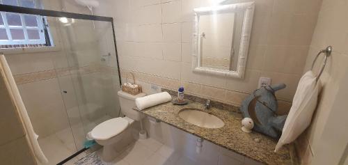 布希奥斯Casa Praia do Forno Búzios, condomínio, 3 quartos的浴室配有卫生间、盥洗盆和淋浴。