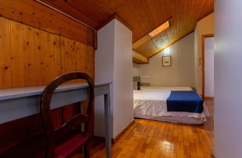 布拉加圣尼古拉酒店的一间卧室配有一张床和一把椅子
