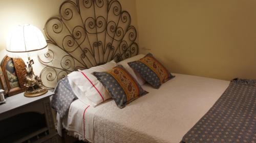 奥利韦拉-杜拜鲁Casa Rural Oliveira do Bairro的一间卧室配有带枕头和台灯的床