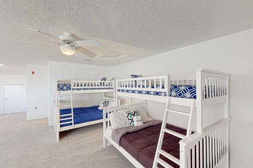 弗吉尼亚海滩The Sandbridge Dunes - Lovely Day 404的一间卧室设有两张双层床和吊扇