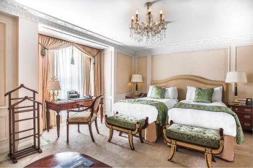 伦敦希尔顿伦敦宾利酒店的一间卧室配有两张床、一张书桌和一个吊灯。