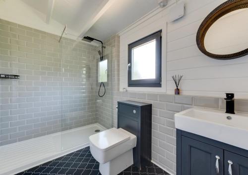 StradbrokeWoodpecker Lodge的浴室配有盥洗盆、卫生间和浴缸。