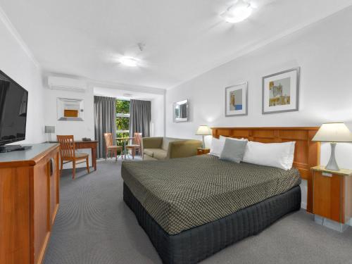 布里斯班Airport Heritage Motel的一间卧室设有一张床和一间客厅。
