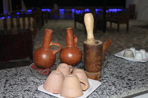 阿斯旺Artika Wadi Kiki Hotel的一组花瓶坐在桌子上