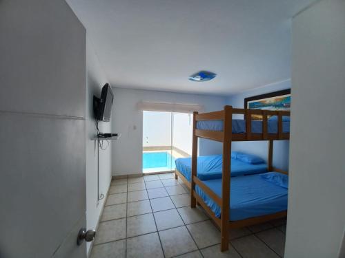 NaploDepartamento con Piscina Privada en Playa Naplo的一间带两张双层床的卧室和一个游泳池
