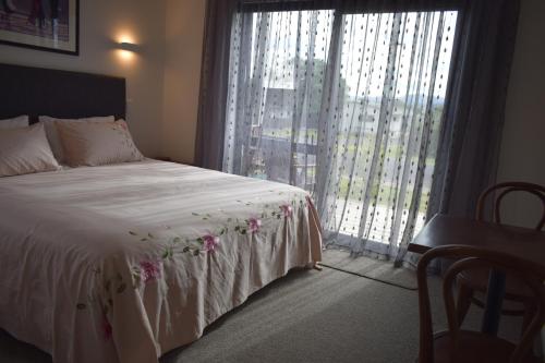 怀蒂昂格Paradise In Whitianga B & B的一间卧室设有一张床和一个大窗户
