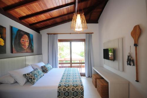 阿拉亚尔达茹达Casa da Praia Arraial d’Ajuda, vem ser feliz!的一间卧室设有一张床和一个大窗户