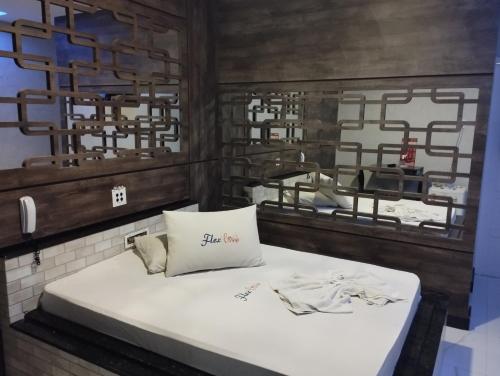 阿拉卡茹Motel FLEX LOVE LAMARAO的一张位于带两面镜子的房间的床铺