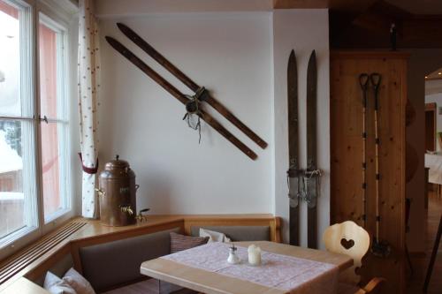 费尔德伯格夏日高山酒店的一间用餐室,配有一张桌子和一些墙上的武器