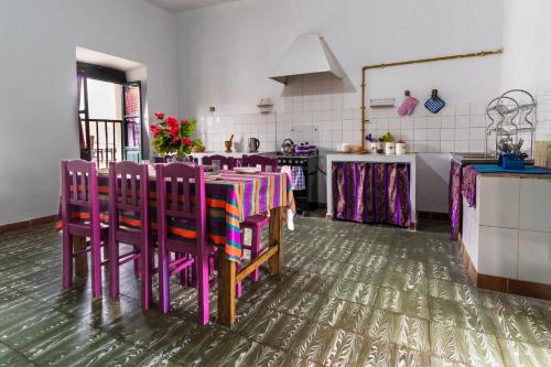 苏克雷Dragonfly Guest House的厨房配有桌子和一些紫色椅子