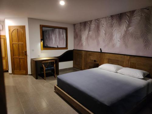 哲帕拉La Collina Villa的一间卧室配有一张床、一张书桌和一台电视