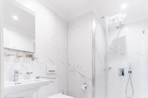 普罗夫迪夫VIZUALIZA Residence Hotel的带淋浴和盥洗盆的白色浴室