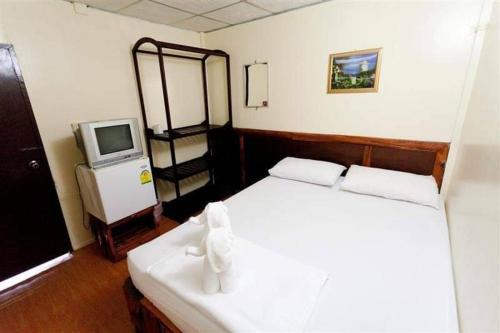 达叻府SSP Bungalow的卧室配有白色的床和电视