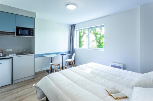 Vern-sur-SeicheAtao Residence- Rennes Sud的卧室配有一张白色的大床和一张桌子