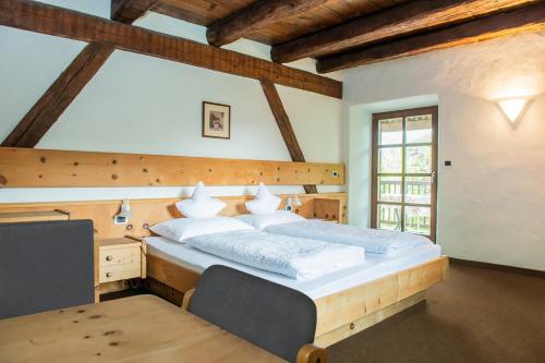 阿皮亚诺苏拉斯特拉达B&B Unterhabsbergerhof的一间卧室配有一张大床和一张桌子