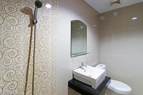 北干巴鲁Paus Guest House Pekanbaru的一间带水槽、卫生间和镜子的浴室