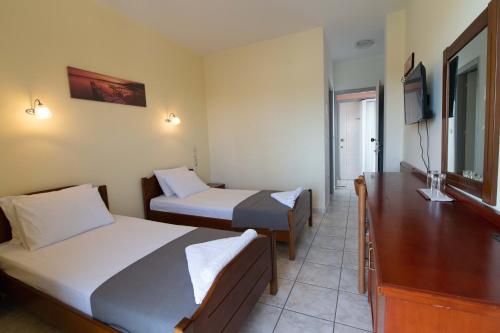 米提卡斯Iraklis Hotel的酒店客房设有两张床和电视。