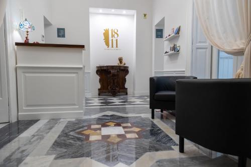 那不勒斯1811 Residenza Storica的一间房间,地板上配有两把椅子和地毯