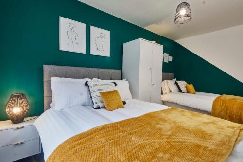 利兹Homebird Property - Salisbury House的一间卧室设有两张床和绿色的墙壁