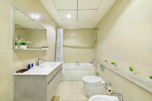 迪拜Maison Privee - High-Floor Trendy Apt with Marina, Palm & Ocean Vws的浴室配有卫生间、盥洗盆和浴缸。