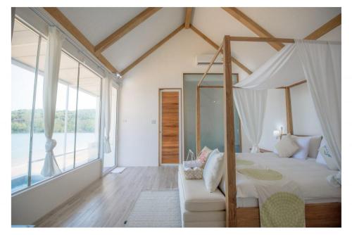 柴老海滩贝壳村度假酒店的一间卧室配有天蓬床和沙发