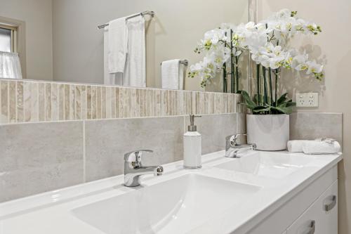 马莱尼The Guesthouse Maleny的浴室设有白色水槽和镜子