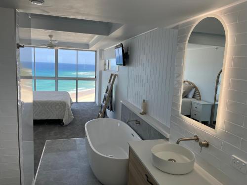 黄金海岸Endless Summer in Cooly Level 18的带浴缸、水槽和镜子的浴室
