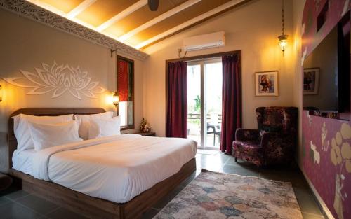瓦伊Gandharv Resorts的卧室配有床、椅子和窗户。