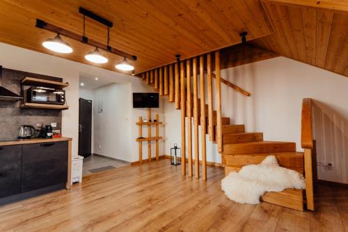 利普托斯基米库拉斯Miracle Seasons的一间铺有木地板并设有一个楼梯的客厅