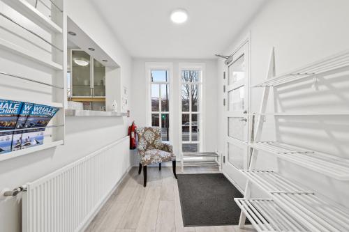 阿克雷里Acco Guesthouse的白色走廊,带椅子和窗户