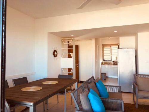 罗驰诺尔Lovely 3-bedroom at Azuri Ocean & Golf village的一间带木桌和蓝色枕头的用餐室