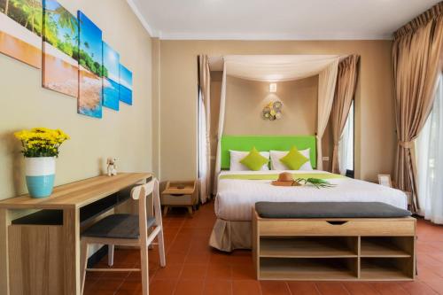 湄南海滩Sea&Sky Beach Resort的配有一张床和一张书桌的酒店客房