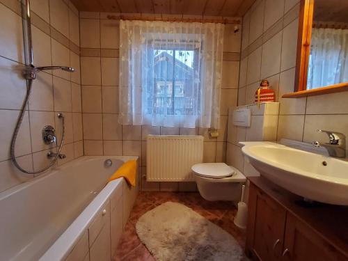 弗林肯贝格Waschhütte, Ferienhaus的带浴缸、盥洗盆和卫生间的浴室