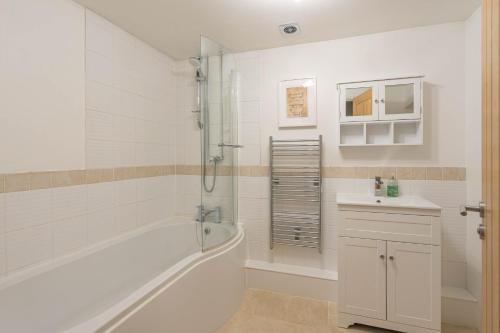 Long WittenhamPondside Barn的白色的浴室设有浴缸和水槽。
