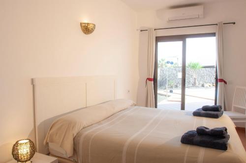 普拉亚布兰卡El jardín de Juanita - ROOMS的一间卧室配有一张床,上面有两条毛巾