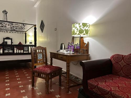 蓬蒂切里Villa Krish的客房设有书桌、椅子和床。