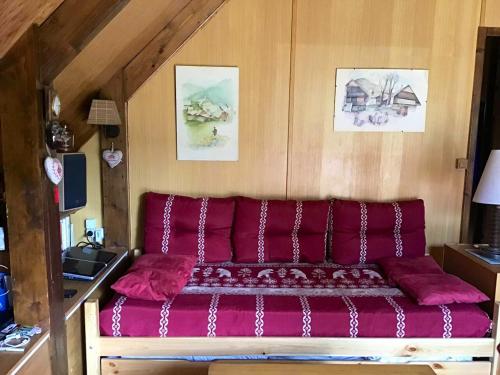 奥特朗Chalet de 2 chambres avec jardin amenage et wifi a Autrans Meaudre en Vercors的红色沙发坐在房间里