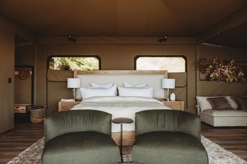 TarakoheDrift Off Grid Luxury Eco Glamping的一间卧室配有一张床和两把椅子