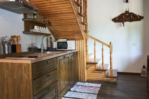 博尔沙Cabana Rose House的厨房配有木制橱柜、水槽和楼梯。