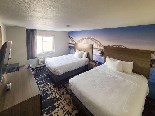 贝滕多夫Clarion Pointe Bettendorf - Quad Cities的酒店客房配有两张床和一张书桌