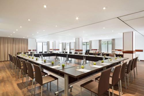 赫罗纳Best Western Premier CMC Girona的大型用餐室配有长桌和椅子