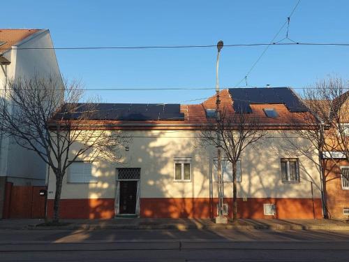 布达佩斯红色机车公寓 的一座白色的建筑,上面有太阳能电池板