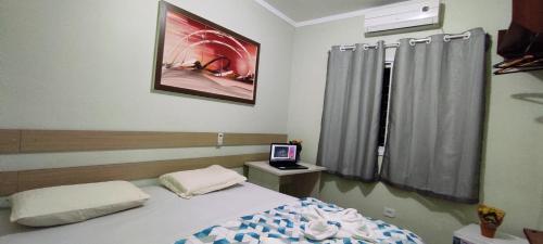 伊瓜苏POUSADA EVELINA的一间卧室配有一张床和一台电视