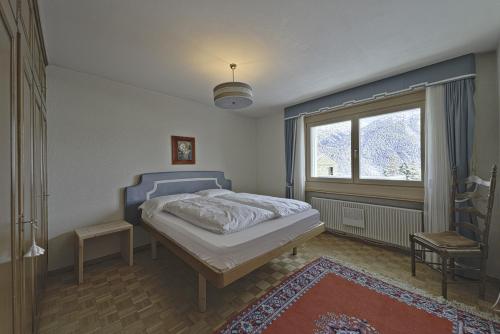 萨梅丹Chesa Chavriol - Samedan的一间卧室设有一张床和一个大窗户