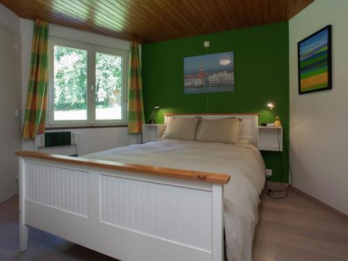 斯图蒙Attractive holiday home in Stoumont with garden的一间卧室设有一张带绿色墙壁的大床