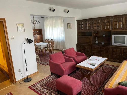 弗尔尼亚奇卡矿泉镇Vidikovac Vrnjačka Banja的客厅配有红色椅子和桌子