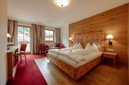 格罗萨尔阿尔特伯斯特酒店的一间卧室配有一张大床和木制床头板