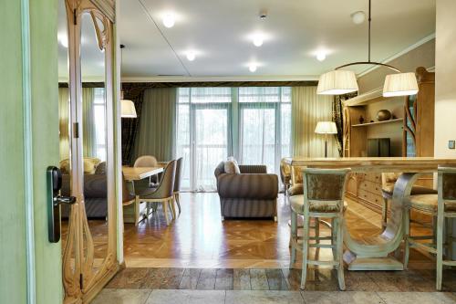 德鲁斯基宁凯立陶宛祖基亚SPA服务式公寓大酒店的厨房以及带桌椅的起居室。