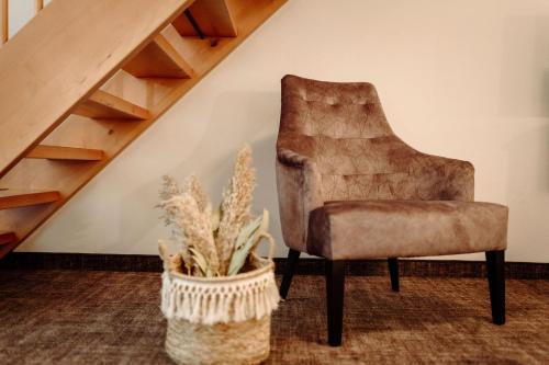 格罗萨尔阿尔特伯斯特酒店的楼梯旁的椅子,有盆栽植物