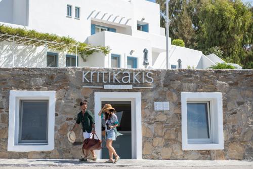 伊奥斯乔拉Kritikakis Village Hotel的走在小猫店外的男人和女人